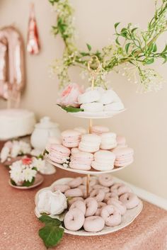 three tiered trays filled with donuts on top of a table