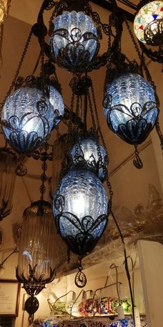 a chandelier with blue glass balls hanging from it's ceiling in a store