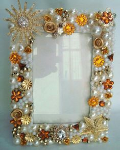 an ornate photo frame decorated with pearls and other jeweled objects, including flowers and leaves