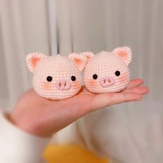 two small crocheted pigs sitting on someone's hand