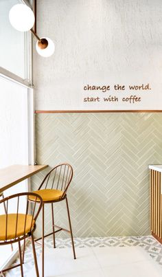 the interior of a coffee shop with chairs and a sign on the wall that says, change the world start with coffee