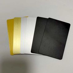 four black and white notebooks are lined up on top of each other in different colors