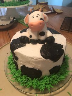 a cake with a cow sitting on top of it