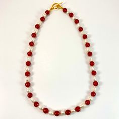 18.5" Strung pomegranate red natural stone beads and natural freshwater pearl beads with gold clasp. Matching earrings with gold s-hooks Elegant Red Beaded Necklaces With Natural Stones, Elegant Red Beaded Necklace With Natural Stones, Elegant Red Beaded Necklace With Lobster Clasp, Elegant Red Pearl Necklace With Natural Stones, Elegant Red Round Pearl Necklace, Red Pearl Necklace With Gemstone Beads, Handmade Red Coral Pearl Necklace, Elegant Red Pearl Necklace With Gemstone Beads, Red Pearl Necklace With Polished Beads As A Gift