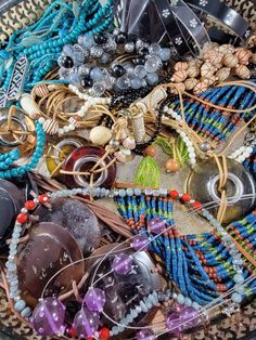 a basket filled with lots of different types of beads and bracelets on top of a table