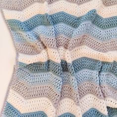 a blue and white crocheted blanket on top of a table