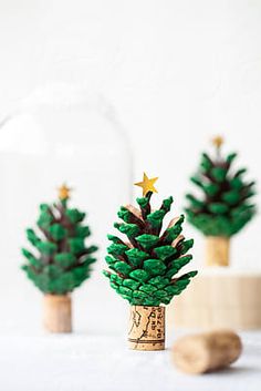 three small trees made out of wine corks sitting next to each other on a table