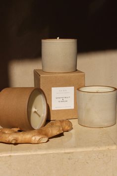 a candle and some ginger root on a counter next to a box with a label