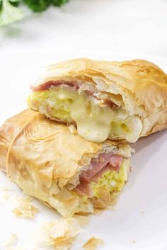 a close up of a pastry with meat and cheese in it on a white plate