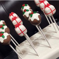 christmas cake pops with white frosting and red bows on them are lined up in a row