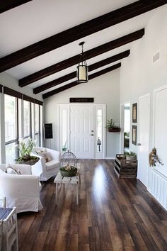 a living room filled with furniture and lots of wood flooring on top of a hard wood floor