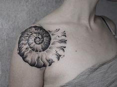 a woman with a tattoo on her chest has a large nauti shell in the center