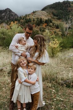 a family poses for a photo in the mountains