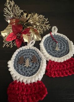 two crocheted christmas ornaments are sitting on a table next to a poinsettia