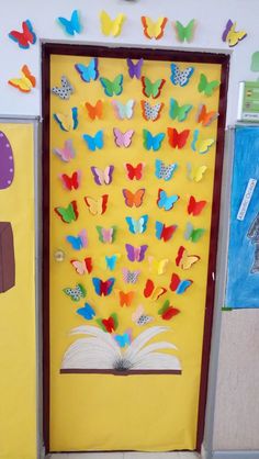 an open book with butterflies on it in front of a bulletin board that is decorated