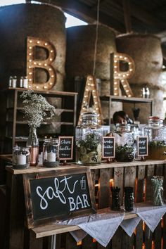 the bar is set up with mason jars and chalkboard signs for guests to sign