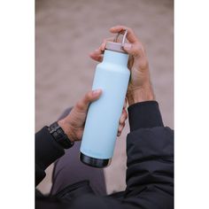 a person holding a water bottle in their hand