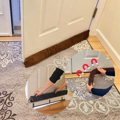 two women are sitting on the floor in front of a mirror and another woman is laying down