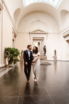 a man and woman are walking through the building