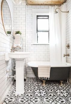 an instagram page with a black and white bathtub in the middle, sink on one side and toilet on the other