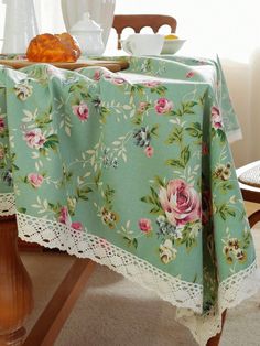 a table with a flowered table cloth on it and some croissants