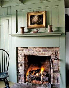 a fire place in a living room with a painting on the wall