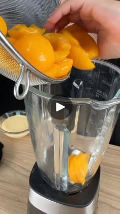 a person is using a blender to make oranges in the blender for making smoothies