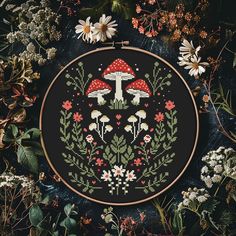 a cross - stitch pattern with flowers and mushrooms on the black background, surrounded by daisies