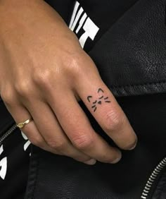 a woman's hand with a small tattoo on her left thumb and the word love written in black ink