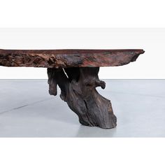 a table made out of wood with a large piece of driftwood on it's side