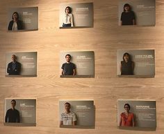 several people are standing in front of a wall with business cards attached to the walls