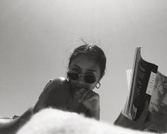 a woman reading a book while laying on her stomach