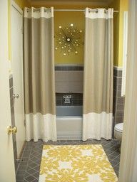 a bath room with a toilet and a bath tub next to a curtained window