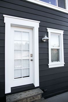 a black house with white trim and two windows