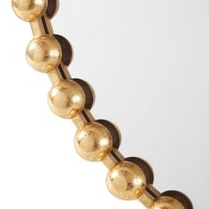 an image of a gold beaded object on a white background