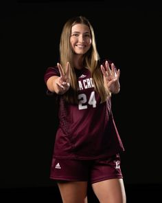 a girl in maroon jersey holding her hands up