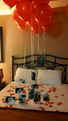 red balloons floating over a bed with pictures on the sheets and pillow cases in front of it