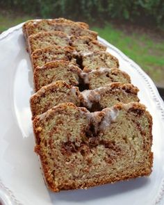 slices of cinnamon swirl bread on a white plate with green grass in the back ground