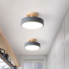 two circular lights are hanging from the ceiling above a kitchen sink and countertop area