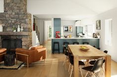 a living room filled with furniture and a fire place in the middle of a kitchen