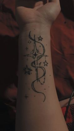 a person's arm with a tattoo on it that reads, and has stars