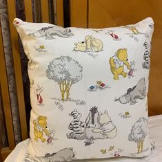 a winnie the pooh pillow sitting on top of a bed