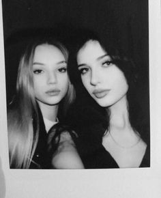 two young women are posing for a photo in front of a black and white background