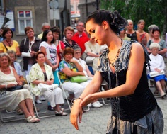 a woman is dancing in front of an audience with her hands out to the side