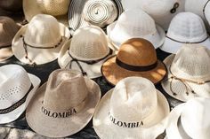 many hats are lined up together on the ground in rows and one is white with black lettering