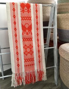 a red and white towel sitting on top of a chair