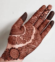 a hand with henna on it that is showing the intricate designs and colors,