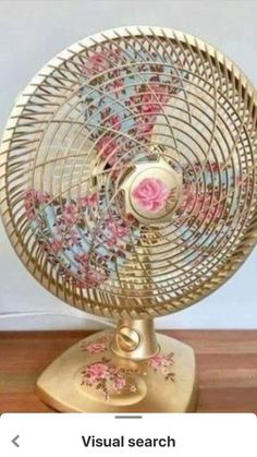 a decorative fan sitting on top of a wooden floor