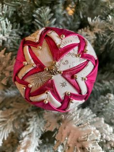 a red and white ornament sitting on top of a christmas tree