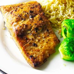 a white plate topped with meat, rice and broccoli